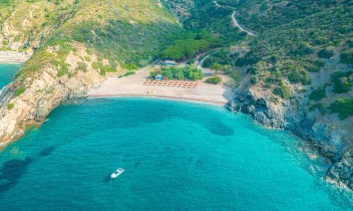 Spiaggia isolata con acque turchesi e una barca.