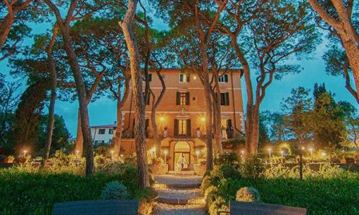 Villa tra gli alberi con illuminazione serale suggestiva.