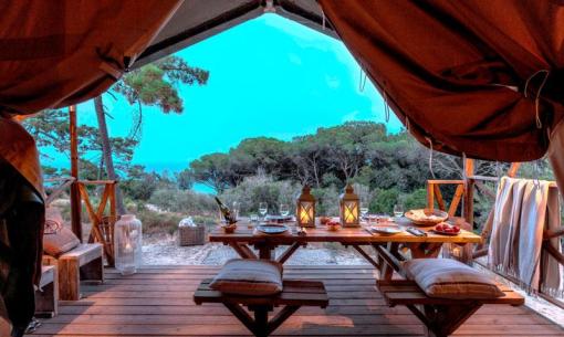 Glamping tent with sea view and set table.