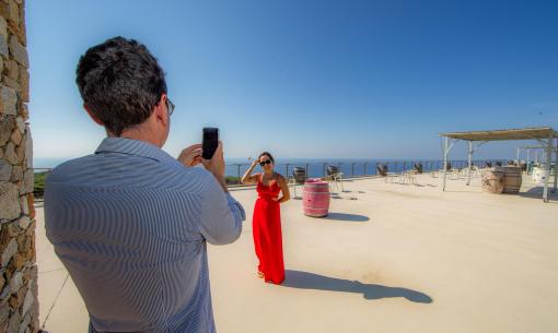 Outdoor photo shoot with sea view, woman in red dress.